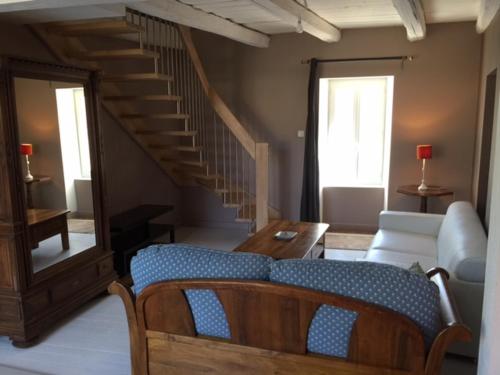 a living room with a couch and a staircase at Gite du Pallie in Rivière-sur-Tarn