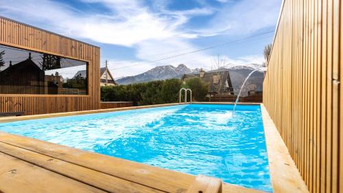 a large swimming pool with a water fountain at Villa Delta Boutique in Kościelisko