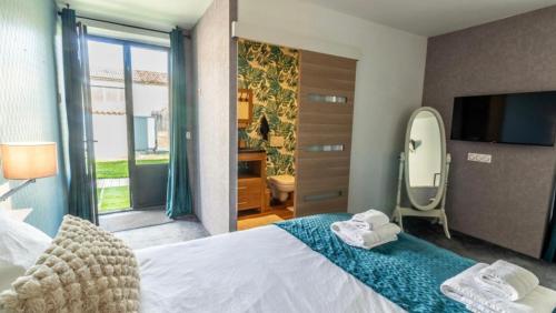 a bedroom with a bed with a mirror and a tv at Domaine Ericarclem in Aigrefeuille-dʼAunis