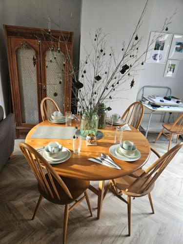 a wooden dining room table with four chairs and a table at Penarth refurbishment in Cardiff