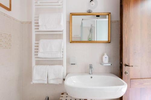 a bathroom with a sink and a mirror and towels at Podere Molinaccio in Panicale