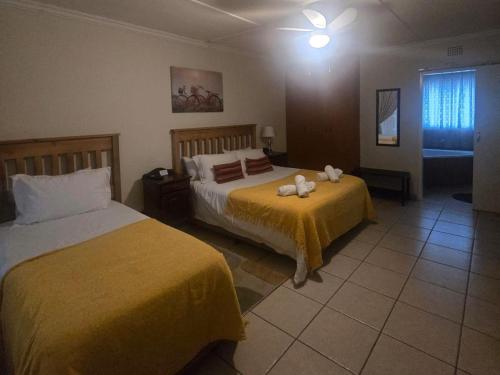 a bedroom with two beds with stuffed animals on it at Swasti Guesthouse in Boksburg