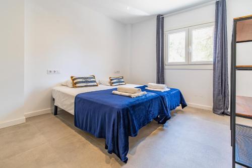 Apartamento Cabrera by Mallorca Infinity في باغيرا: غرفة نوم بسرير وملاءات زرقاء ونافذة