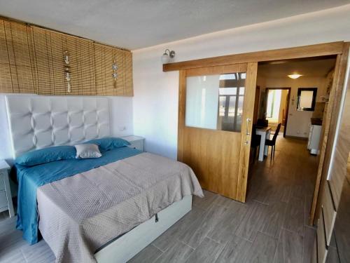 Un dormitorio con una cama grande con una manta azul. en Appartamento MISTERHOLIDAY RIVALTA, en Costa de Antigua