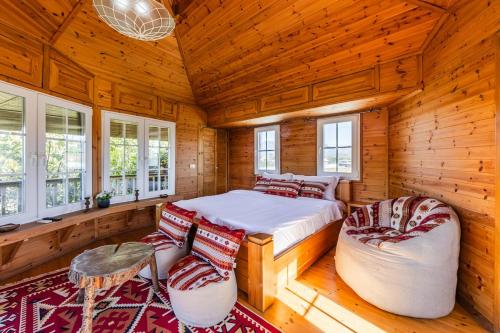 a bedroom with a bed and two chairs and windows at The Animals Farm Double Room in Tirana