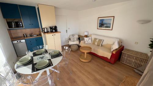 a small living room with a table and a couch at Evasion en bord de Mer in Quiberon