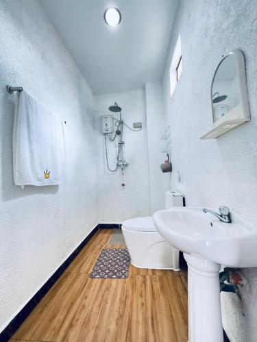 a white bathroom with a sink and a toilet at Panda Guest House in Coron