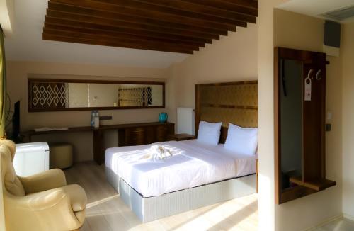 a bedroom with a white bed and a chair at HK Resort 