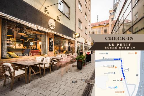a street with tables and chairs in front of a store at Petit Dependance in Bratislava