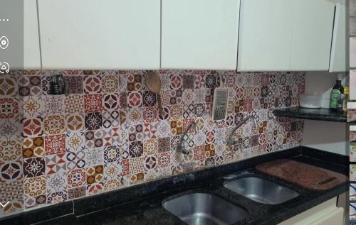 een keuken met een wastafel en een tegelwand bij Casabeiramaritamaracá in Itamaracá