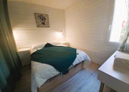 ein kleines Schlafzimmer mit einem Bett mit einem grünen Kissen in der Unterkunft Gaspro3 - Maison une chambre climatisée proche de St Tropez in Gassin