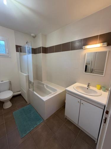 un bagno con vasca, lavandino e WC di Maison vue sur le lac et proche du golf ! a Bourges