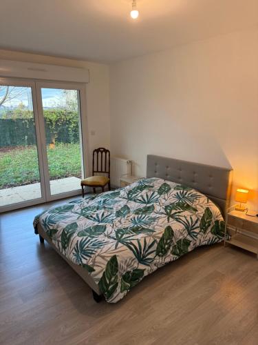 una camera da letto con un letto con un copriletto colorato di Maison vue sur le lac et proche du golf ! a Bourges