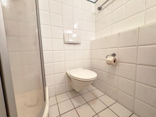 a white bathroom with a toilet and a shower at 33 - 11 Hotelkamer voor twee personen in Marx in Bunkenburg