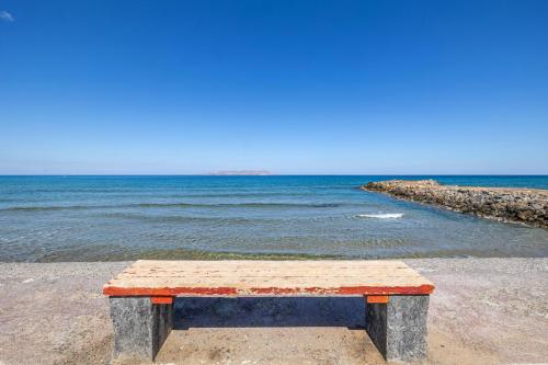 Niros Beachfront Aparthotel في كوكيني خانيون: جلسة على الشاطئ قرب الماء