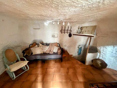 阿尔卡拉德尔胡卡尔Casa cueva del sastre Alcalá del Júcar的房间里有一张沙发和一张桌子