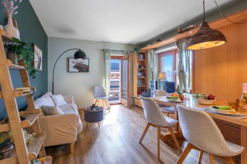 eine Küche und ein Wohnzimmer mit Tisch und Stühlen in der Unterkunft Appartamento Alpine Suite - Happy Rentals in Sestriere