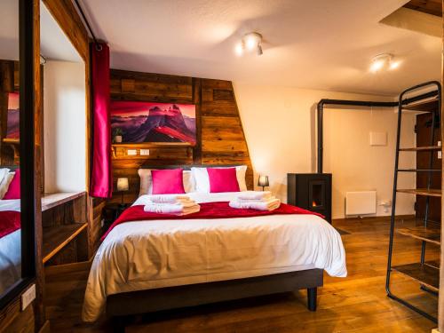 ein Schlafzimmer mit einem großen Bett mit roter Bettwäsche in der Unterkunft ALP BREAK 1 - Nel Borgo Storico del Ponte Romano in Aosta