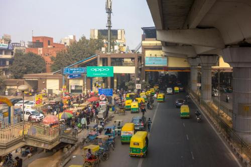 a busy city street filled with cars and buses at Indraprastha BNB Home in New Delhi
