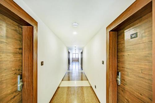 um corredor num edifício com portas de madeira em FabHotel Pride Image - Rajarajeshwari Nagar em Bangalore