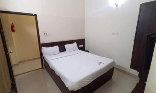 um quarto com uma grande cama branca em um quarto em FabHotel Pride Image - Rajarajeshwari Nagar em Bangalore