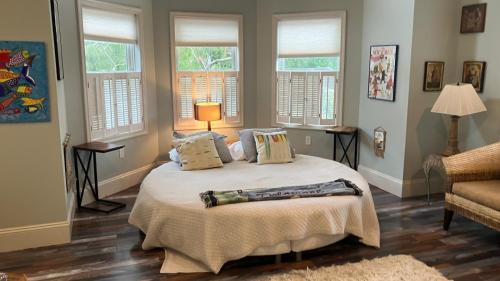 a bedroom with a bed with pillows and windows at Rehoboth Beach Haven in Rehoboth Beach