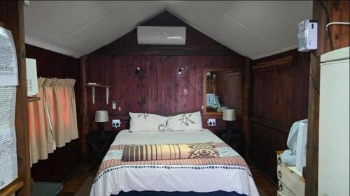 ein Schlafzimmer mit einem Bett in einem Zimmer mit Holzwänden in der Unterkunft Kelso lifestyle in Kelso
