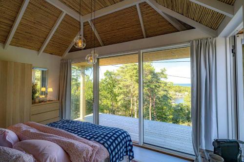 een slaapkamer met een bed en een groot raam bij Architectural Gem Between Risør And Kragerø in Søndeled