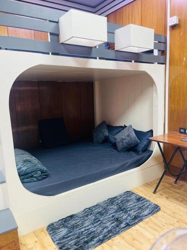 a bunk bed in a room with a table at Dormyy backpackers castle in Guwahati