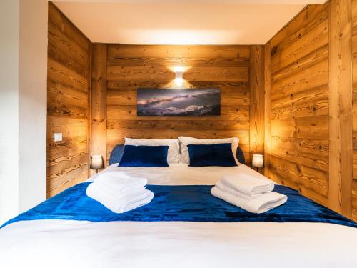 ein Schlafzimmer mit einem großen Bett mit Holzwänden in der Unterkunft ALP BREAK 2 - Nel Borgo Storico del Ponte Romano in Aosta