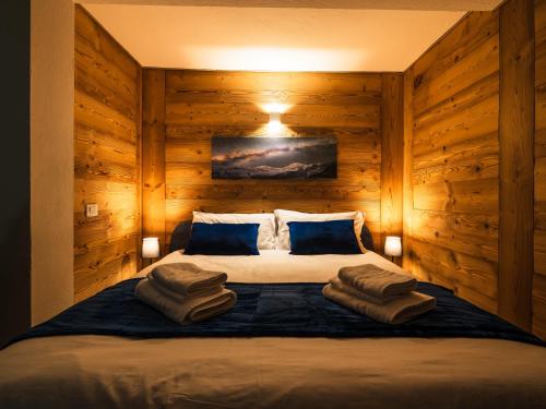 ein Schlafzimmer mit einem großen Bett mit Holzwänden in der Unterkunft ALP BREAK 2 - Nel Borgo Storico del Ponte Romano in Aosta
