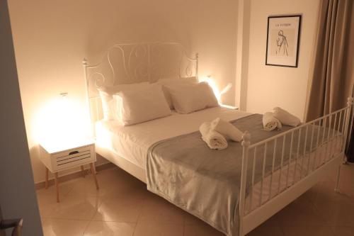 a bedroom with a white bed with a white crib at Lepanto Port Vibes in Nafpaktos