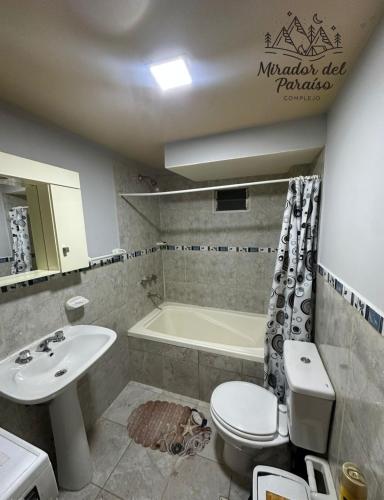 a bathroom with a sink and a toilet and a tub at Cabaña Mirador del Paraíso in Ushuaia