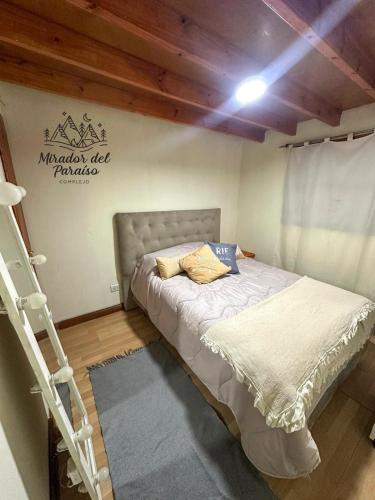 a bedroom with a bed and a ladder in it at Cabaña Mirador del Paraíso in Ushuaia