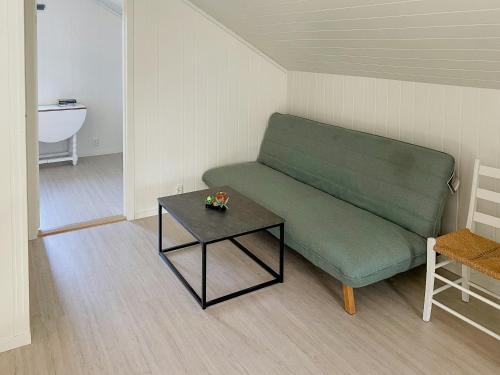 a living room with a green couch and a table at Hyggeligt Familiehus Omgivet Af Ø-Landskab in Fitjar