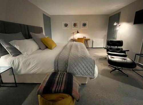 a bedroom with a bed and a chair and a desk at Aald Harbour Hoose, Shetland Islands in Lerwick