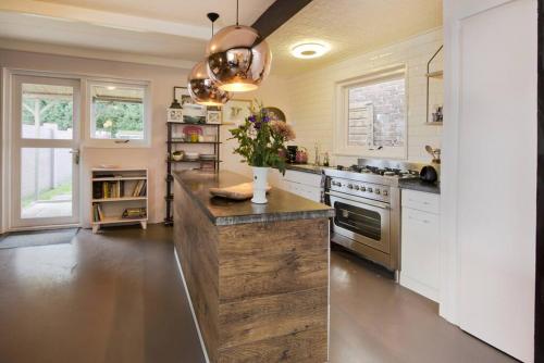 une cuisine avec un grand îlot en bois au milieu dans l'établissement Lovely Studio with Patio and Garden, à Westenschouwen
