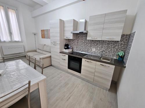 Una cocina con gabinetes blancos y encimera. en Al Vecchio Orologio, en Viterbo