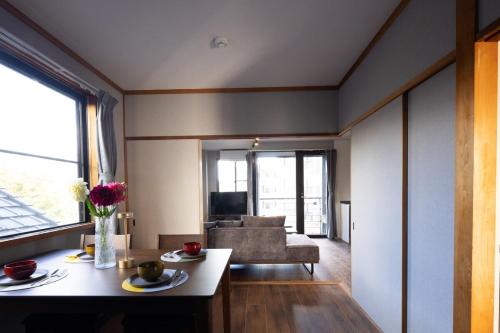 a living room with a table and a couch at UNITED GARDEN hotel 宇都宮駅前3階 in Utsunomiya