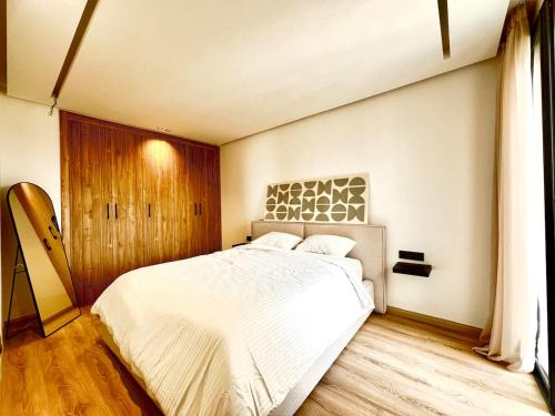 卡萨布兰卡Cozy studio with terrace France ville的卧室配有一张白色床和木地板