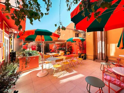 a patio with tables and chairs and umbrellas at Ostello Bello Bologna in Bologna
