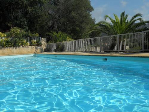 une grande piscine bleue à côté d'une clôture dans l'établissement Le Rayol, à Rayol-Canadel-sur-Mer