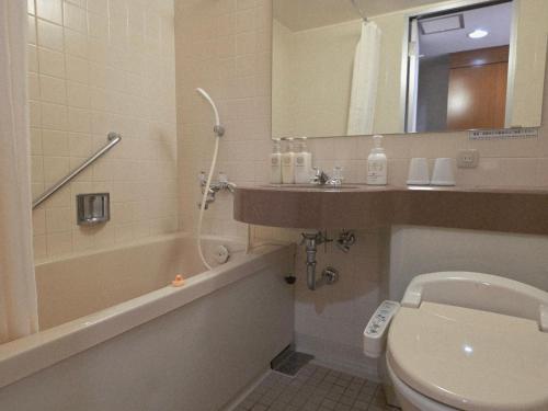 a bathroom with a sink and a toilet and a tub at UrbanHotelTokyoShinmatsudo in Matsudo