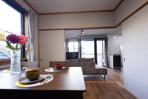 a living room with a table and a couch at UNITED GARDEN hotel 宇都宮駅前3階 in Utsunomiya