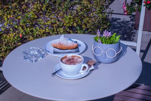 einen weißen Tisch mit einer Tasse Kaffee und einem Kuchen in der Unterkunft Culture Hotel Centro Storico in Neapel