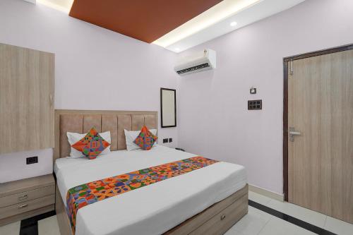 a bedroom with a large bed and a wooden door at FabHotel Yatri Nivas - Assi Ghat in Varanasi
