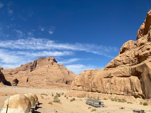 ワディ・ラムにあるAllen Luxury Wadi Rumの砂漠の岩の近くのキャンピングカー