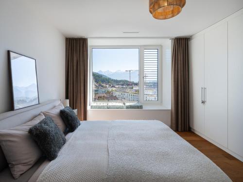 Un dormitorio con una cama grande y una ventana grande en Exclusive SKY Penthouse in Thun, en Thun