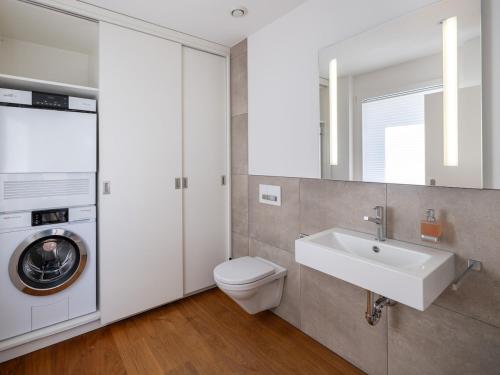 Un baño con lavabo y lavadora. en Exclusive SKY Penthouse in Thun, en Thun