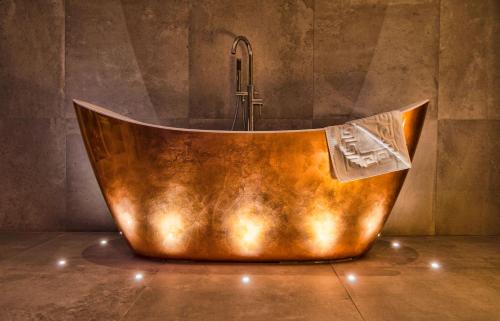 a copper tub with a shower in a bathroom at Landal North Lakes in Brayton Station